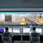 Pessoas monitoram telas digitais e sistemas de computador em uma moderna central de operações.
