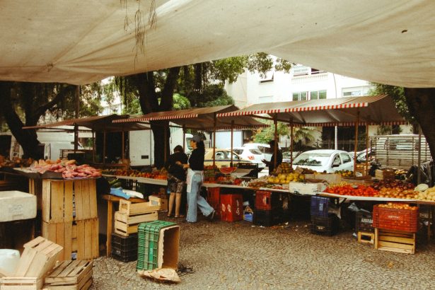 Mercado ao ar livre no Rio de Janeiro, com barracas de produtos frescos sob uma cobertura.