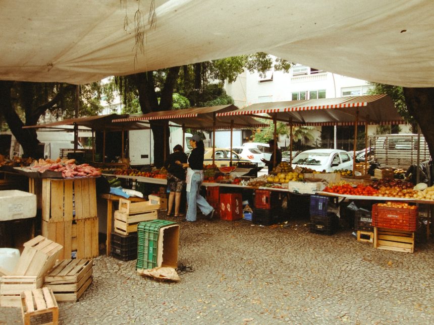 Mercado ao ar livre no Rio de Janeiro, com barracas de produtos frescos sob uma cobertura.